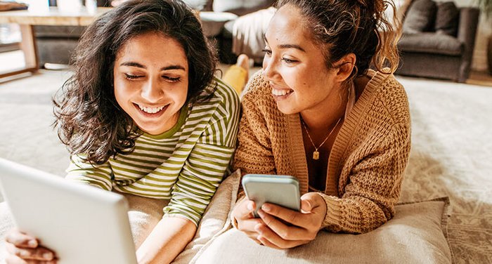 Zwei Frauen mit Smartphone und Laptop