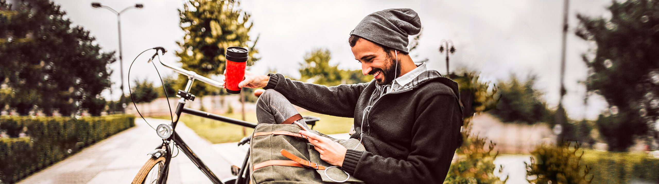 Foto von Person auf einer Sitzbank beim benutzen eines Smartphones.