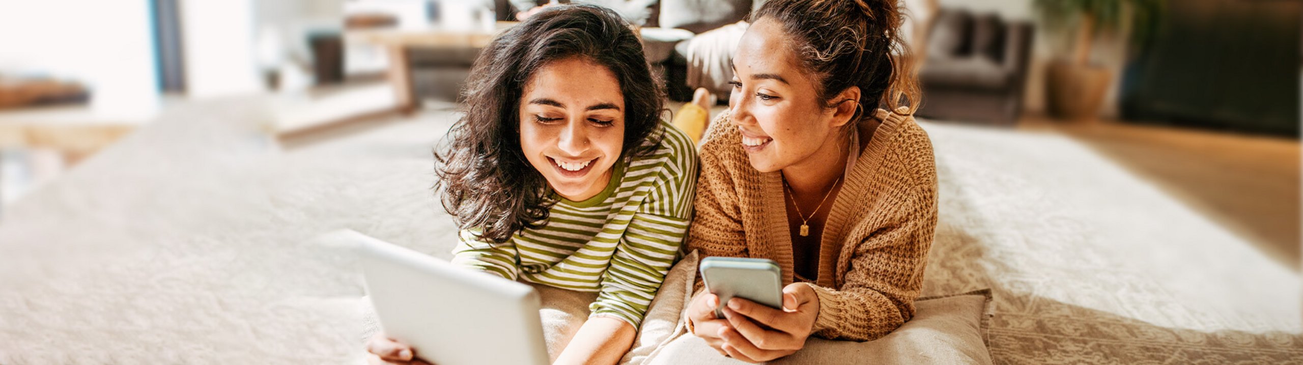 Zwei Frauen nutzen Smartphone und Tablet