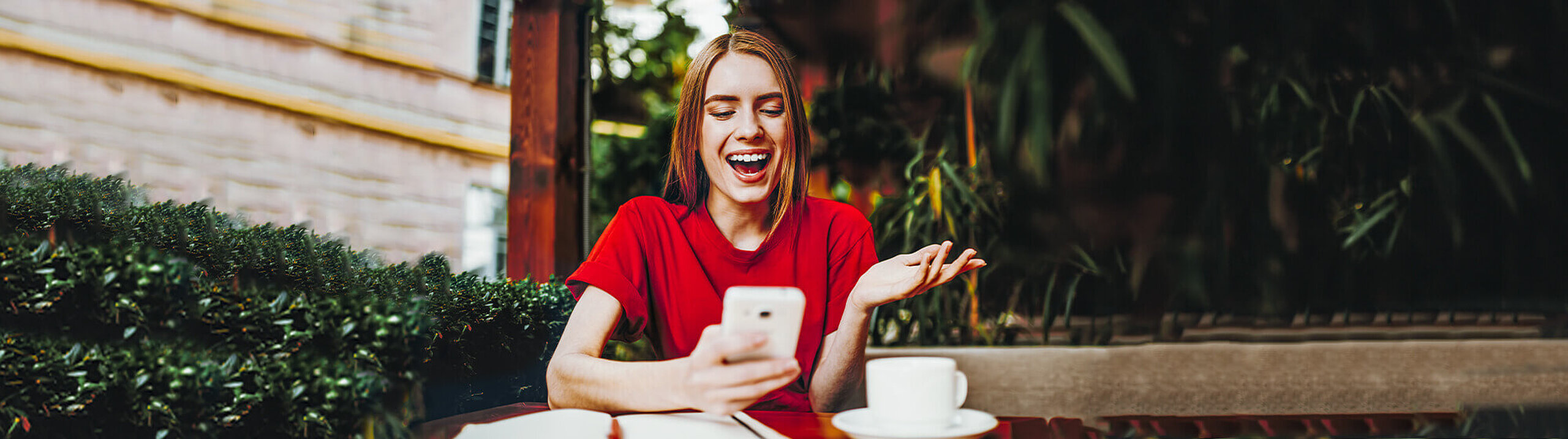 Frau schaut lachend auf ihr Smartphone