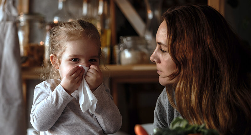 Mutter schaut nach Ihrer erkälteten Tochter