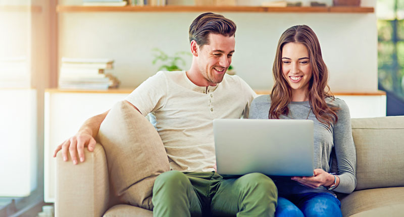 Pärchen mit Laptop auf dem Sofa