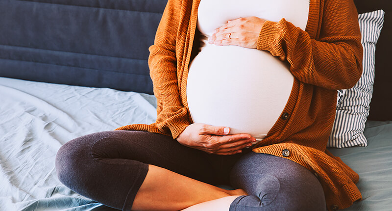 Schwangere Frau hält ihren Bauch