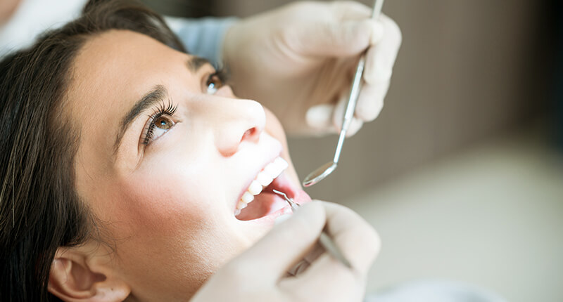 Patientin wird beim Zahnarzt untersucht