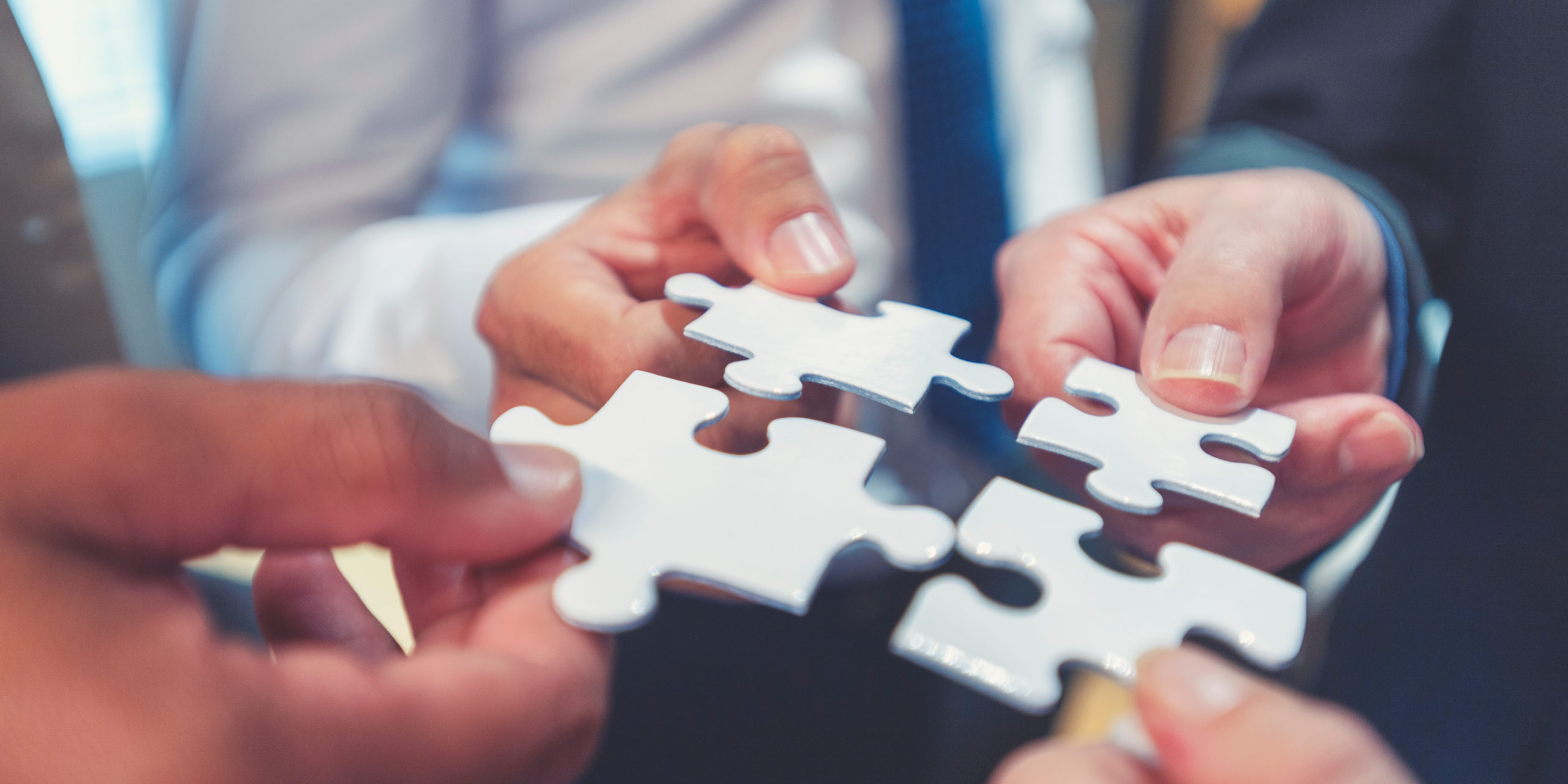 Menschen halten Puzzlestück zusammen